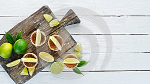 Tequila with salt and lime on a white wooden background. Top view. Free space