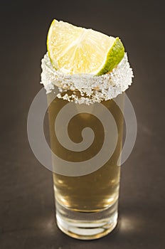 Tequila shot with lime fruit/Tequila shot with lime fruit on a dark background