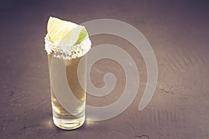 Tequila shot with lime fruit/Tequila shot with lime fruit on a dark background. Copyspace