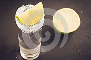 Tequila shot with lime fruit/Tequila shot with lime fruit on a dark background. Selective focus