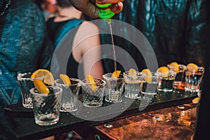 Tequila shot with lime and sea salt on black table, selective focus