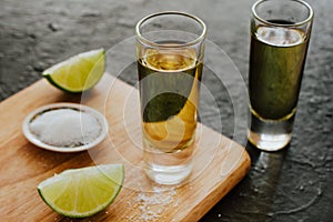 Tequila shot, mexican Alcoholic strong drinks and pieces of lime with salt in mexico