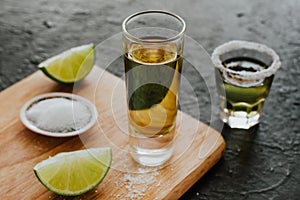 Tequila shot, mexican Alcoholic strong drinks and pieces of lime with salt in mexico