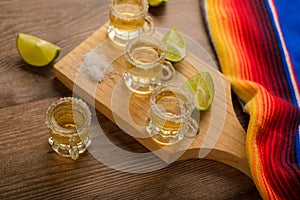 Tequila shots with salt and lime on a bar table.