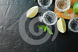 Tequila shots with salt, lime slices and mint