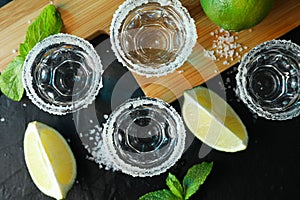 Tequila shots with salt, lime slices and mint