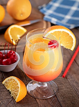 Tequila sunrise cocktail with cherry and orange slice