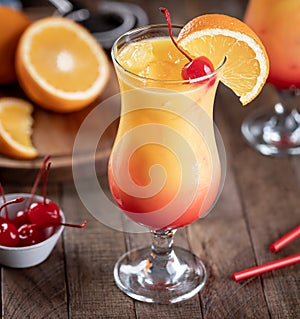 Tequila sunrise cocktail garnished with cherry and orange slice