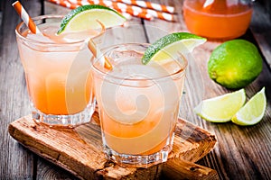 Tequila sunrise cocktail with ice and lime