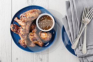 Teriyaki chicken wings with sauce on white table top