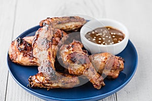 Teriyaki chicken wings with sauce on white table top