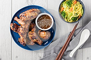 Teriyaki chicken wings serves with noodles and sauce