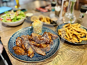 Teriyaki chicken wings under cherry souse with sesame seeds