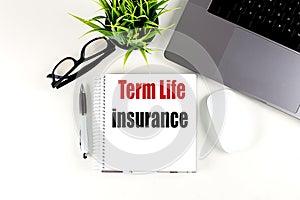 TERM LIFE INSURANCE text on notebook with laptop, mouse and pen