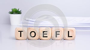 the term 'toefl' is inscribed on wooden blocks, creating a front-view composition