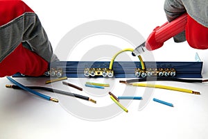 Terminal block electrical wires and hands in red gloves  on white background