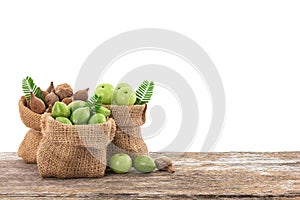 Terminalia bellirica , terminalia chebula and phyllanthus emblica fruits in sack on the wooden table with clipping path