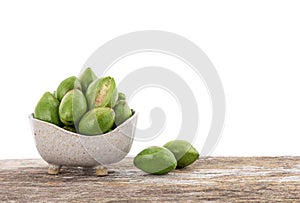 Terminalia chebula or chebulic myrobalans fruits in bowl on the wooden table with clipping path