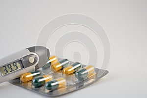 A termometr with high temperature and antibiotics pills.