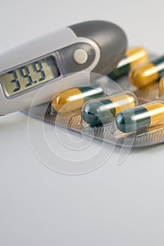 A termometr with high temperature and antibiotics pills.