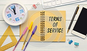 TERMS OF SERVICE is written on a notepad