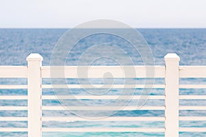 Terrace or balcony with wooden white fence, sea or ocean and clear sky, seascape background. Copyspace