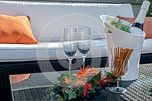 Terrace with champagne glasses and champagne bottle in cooler