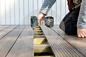 Terrace deck construction - man installing wpc composite decking boards