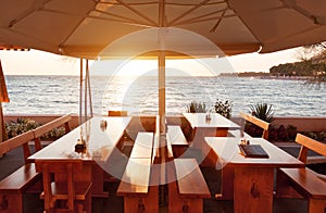 Terrace restaurant tables under parasol at sunset