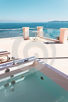 Terrace with sun loungers, outdoor hot tub and sea views. Relaxed holidays in a Mediterranean resort in Greece