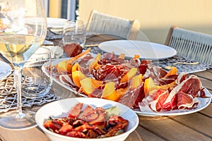 A terrace table in Italy graced with the classic pairing of sweet melon and savory Prosciutto under the golden afternoon sun