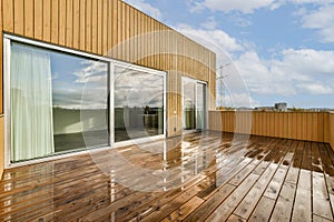 a terrace with wooden floors and a glass window