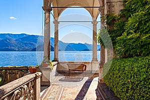 A terrace with a wooden sofa in the garden of a big villa on lake Como, Lombardia, Italy