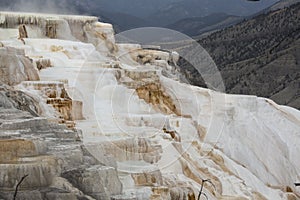 Terraces and steams of geothermal activity in a mountain landscape.