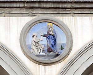 Terracotta relief of a Franciscan saint by Andrea della Robbia in a spandrel of the Hospital of San Paolo in Florence, Italy.