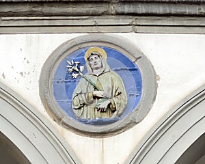 Terracotta relief of a Franciscan saint by Andrea della Robbia in a spandrel of the Hospital of San Paolo in Florence, Italy.