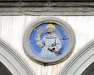 Terracotta relief of a Franciscan saint by Andrea della Robbia in a spandrel of the Hospital of San Paolo in Florence, Italy.