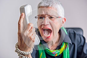 Terrible service, angry senior woman yelling at phone