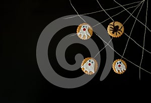 Terribly terribly tasty cookies with spiders, nasty cobwebs and ghosts on a black background.