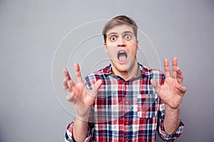Terrified frightened young man screaming with open mouth