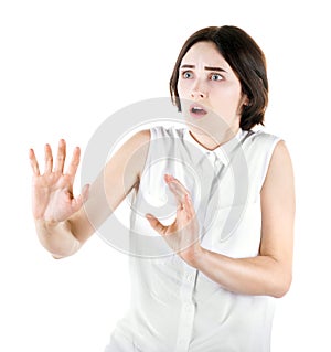 A terrified girl isolated on a white background. A scared girl protecting herself. Lady in a white blouse. Emotional young woman.