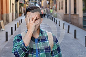 Terrified man covering his face outdoors