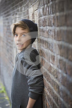 Terrified teenager boy leaning on a wall