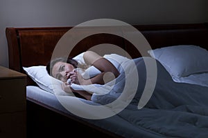 Terrified woman lying in bed photo