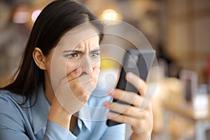 Terrified woman watching media content on phone