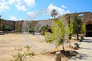 The territory of the fortress of the city of Kyrenia with arches, stairs, trees and a large empty area