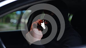 Terrorist in a black mask in a car