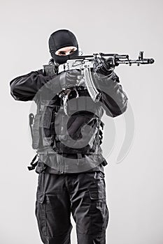 Terrorist holding a machine gun in his hands aim isolated over white