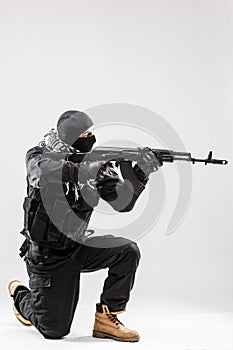 Terrorist holding a machine gun in his hands aim isolated over white