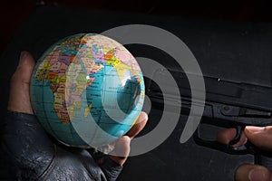 Terrorist put a gun to globe.